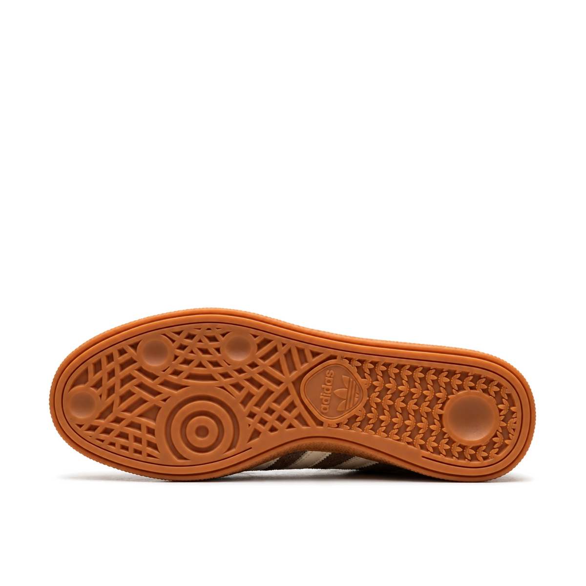 Gum outsole of the brown Handball Spezial, with circular forefoot tread on the left and repeating Trefoils at the heel on the right.