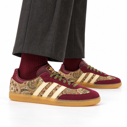 adidas x Liberty London Samba OG – Maroon Paisley worn with charcoal pleated trousers and burgundy ribbed socks, both shoes facing right