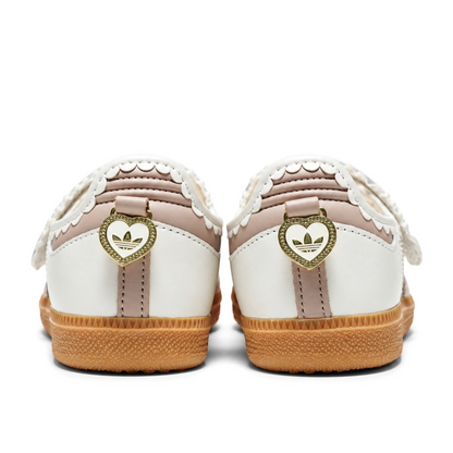 Rear view of white and pink Samba Jane Ruffle shoes with gold heart-shaped heel charms above the gum soles.