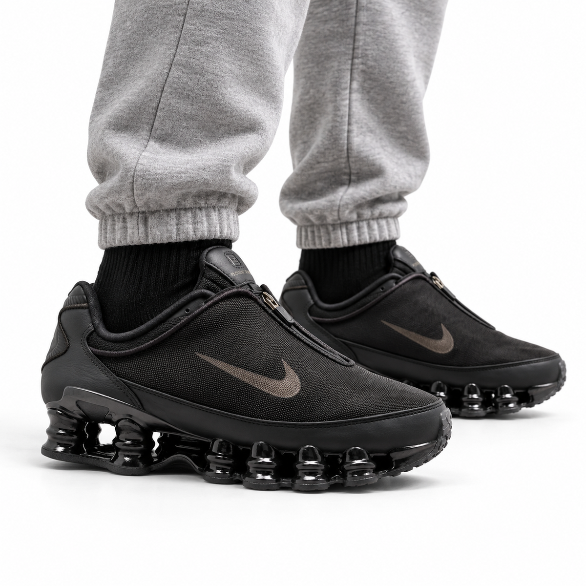 Nike Shox TL Winterized Unisex Sneakers – Black/Cave Stone worn with heather grey cuffed sweatpants and black socks, both shoes facing right