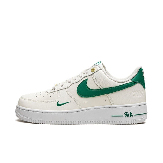 A pair of Nike Air Force 1 'Malachite White' sneakers with a classic white tumbled leather upper and green detailing.